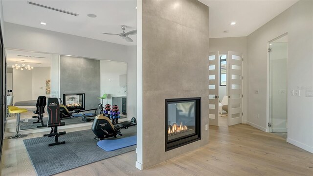 1540 Hillview Dr, Sarasota, FL 34239 - workout area featuring baseboards, visible vents, a tiled fireplace, ceiling fan, and wood finished floors