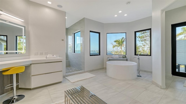 1540 Hillview Dr, Sarasota, FL 34239 - bathroom with vanity, a soaking tub, tile patterned flooring, walk in shower, and baseboards