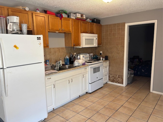 3255 51st Avenue Dr W, Bradenton, FL 34207 - kitchen with light countertops, a sink, a textured ceiling, light tile patterned floors, and white appliances