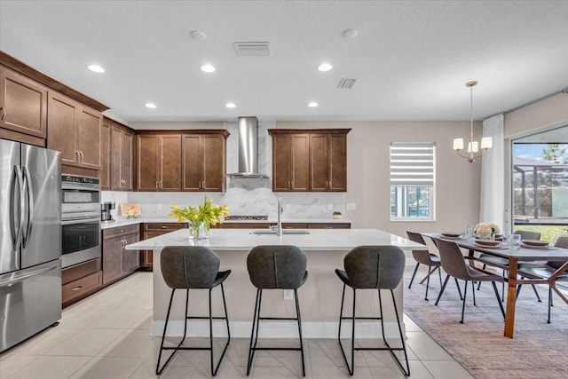 17502 Savory Mist Cir, Bradenton, FL 34211 - kitchen with stainless steel appliances, wall chimney exhaust hood, a sink, backsplash, and a breakfast bar