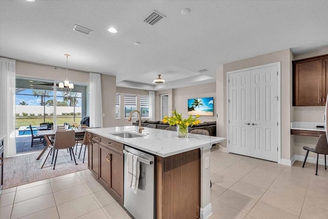 17502 Savory Mist Cir, Bradenton, FL 34211 - kitchen featuring a sink, dishwasher, open floor plan, light tile patterned floors, and an island with sink