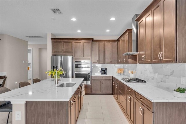 17502 Savory Mist Cir, Bradenton, FL 34211 - kitchen with stainless steel appliances, a sink, a kitchen breakfast bar, wall chimney range hood, and tasteful backsplash