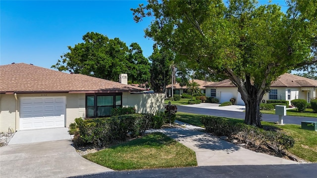 ranch-style house featuring a garage, driveway, a chimney, and stucco siding