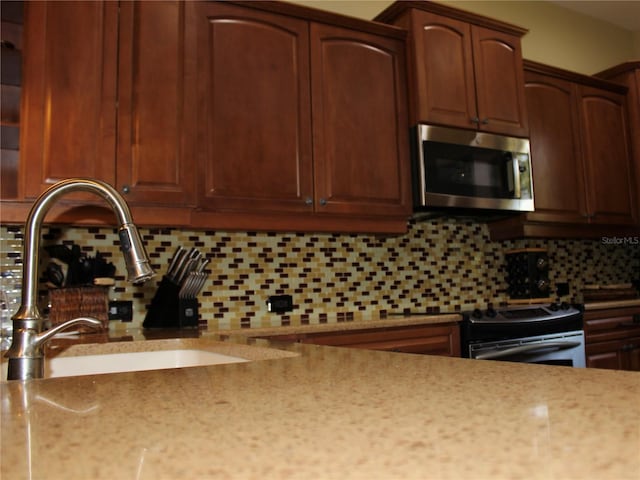 406 Petrel Trl, Bradenton, FL 34212 - kitchen with tasteful backsplash, light stone countertops, appliances with stainless steel finishes, and a sink
