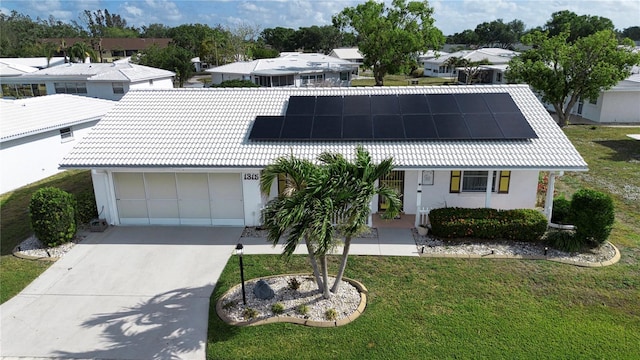1315 Bottlebrush Dr, Bradenton, FL 34208 - view of front of home with a tile roof, stucco siding, a front yard, solar panels, and a garage