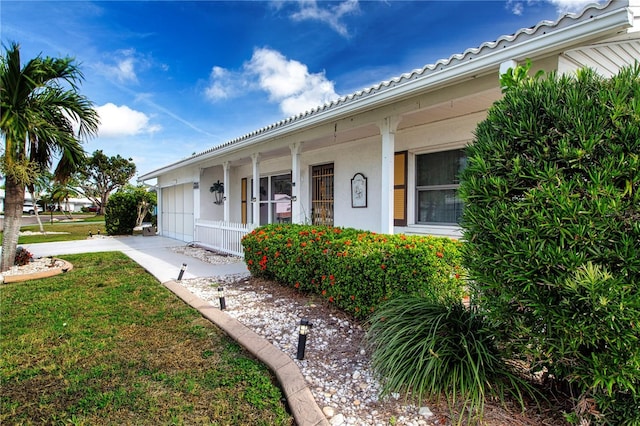 1315 Bottlebrush Dr, Bradenton, FL 34208 - exterior space with a garage, stucco siding, driveway, covered porch, and a yard