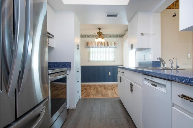 1315 Bottlebrush Dr, Bradenton, FL 34208 - kitchen with stove, a sink, dishwasher, freestanding refrigerator, and wainscoting