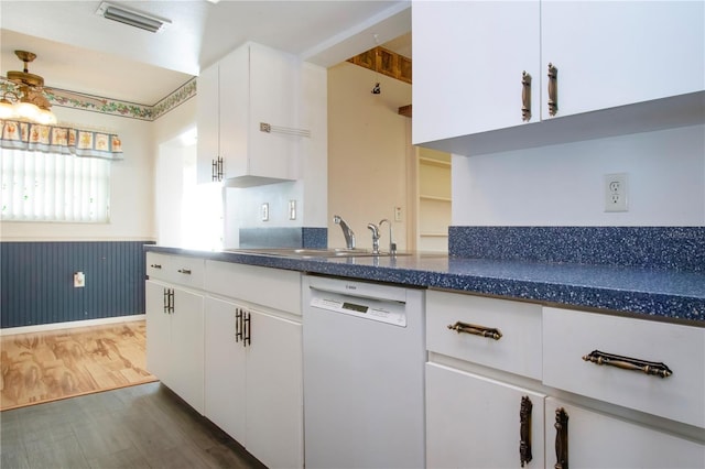 1315 Bottlebrush Dr, Bradenton, FL 34208 - kitchen with dishwasher, wood finished floors, white cabinetry, a sink, and wainscoting