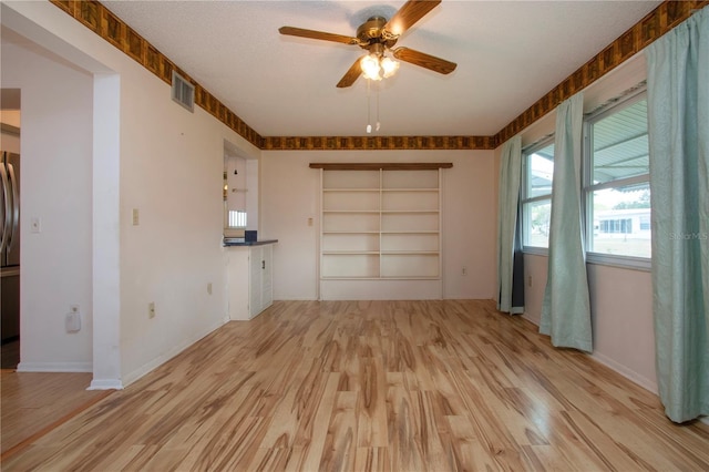 1315 Bottlebrush Dr, Bradenton, FL 34208 - spare room with baseboards, a textured ceiling, visible vents, a ceiling fan, and wood finished floors