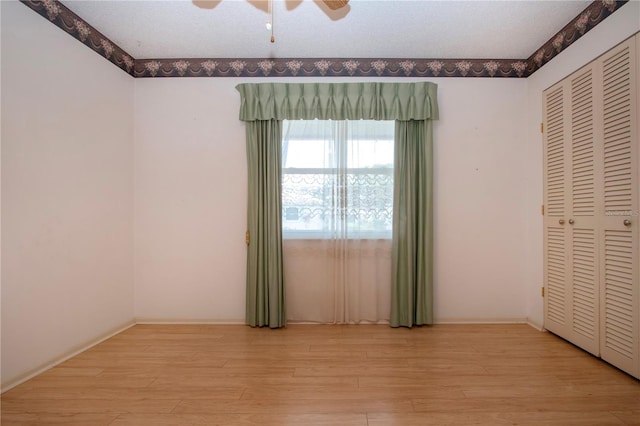 1315 Bottlebrush Dr, Bradenton, FL 34208 - unfurnished bedroom with a closet, a textured ceiling, baseboards, a ceiling fan, and light wood-type flooring