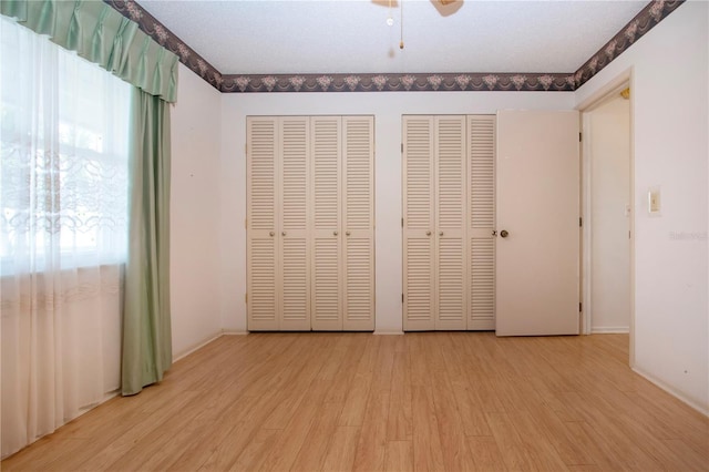 1315 Bottlebrush Dr, Bradenton, FL 34208 - unfurnished bedroom with two closets, a ceiling fan, and wood finished floors