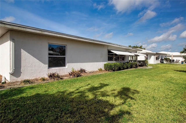 1315 Bottlebrush Dr, Bradenton, FL 34208 - view of home's exterior with a lawn and stucco siding