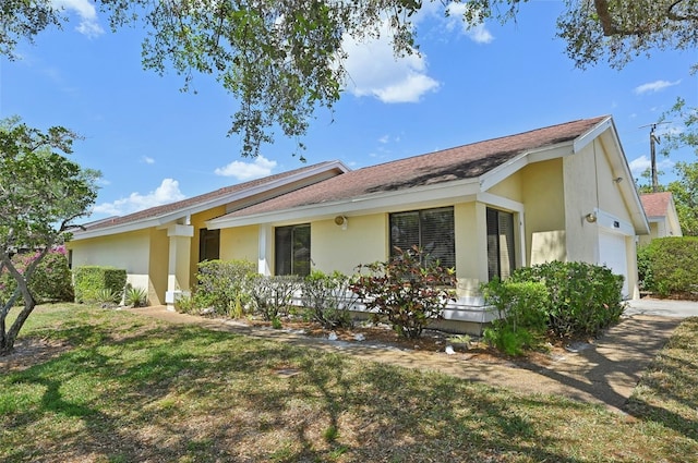 view of property exterior featuring stucco siding, a yard, and an attached garage