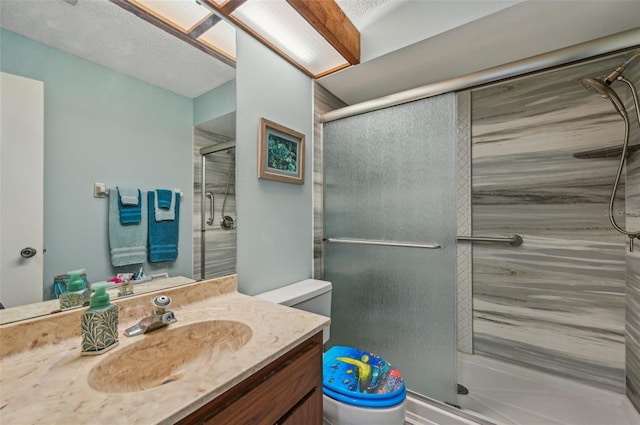 bathroom featuring a stall shower, toilet, and vanity