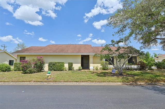 ranch-style house with stucco siding and a front lawn