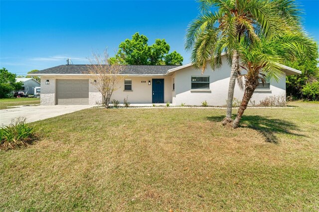 single story home with stucco siding, concrete driveway, an attached garage, and a front lawn