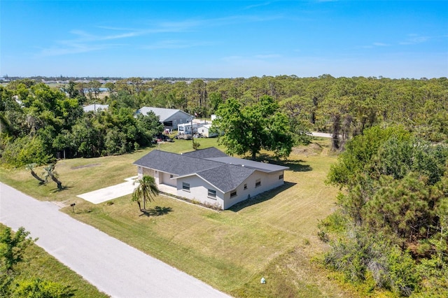aerial view of property and surrounding area featuring a forest