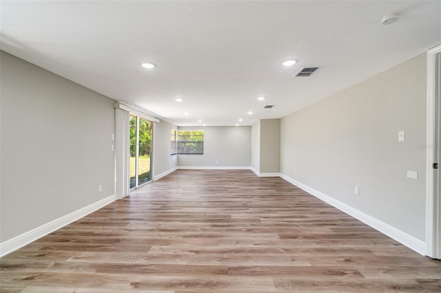 unfurnished room featuring recessed lighting, a smoke detector, light wood-type flooring, and baseboards