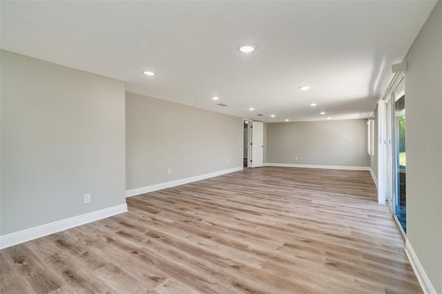 empty room with recessed lighting, light wood-style flooring, and baseboards