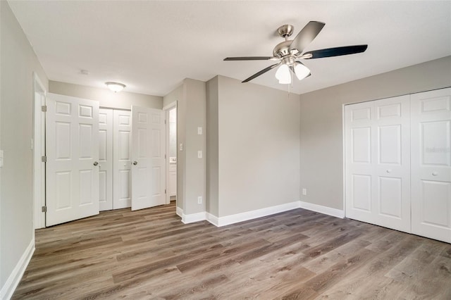 unfurnished bedroom with wood finished floors, baseboards, and ceiling fan