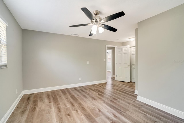 spare room with light wood-style floors, ceiling fan, and baseboards