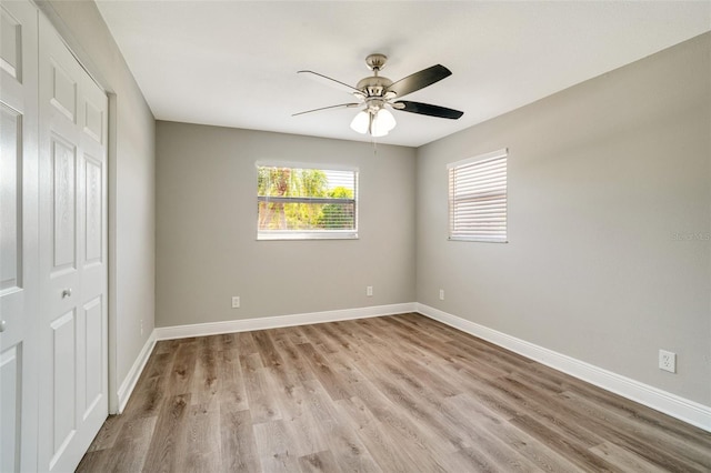 unfurnished bedroom with light wood-type flooring, baseboards, and ceiling fan