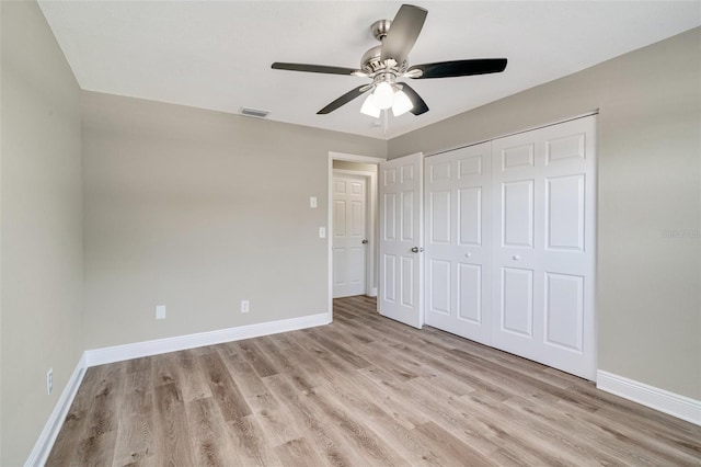 unfurnished bedroom featuring baseboards, light wood-type flooring, a closet, and ceiling fan