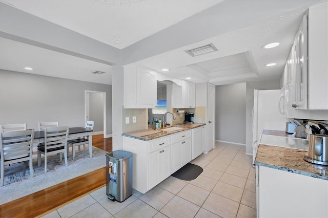 4806 Huntleigh Dr, Sarasota, FL 34233 - kitchen with light tile patterned floors, visible vents, recessed lighting, white cabinets, and a sink