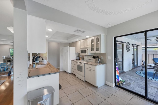 4806 Huntleigh Dr, Sarasota, FL 34233 - kitchen with glass insert cabinets, white appliances, a wealth of natural light, visible vents, and a sink