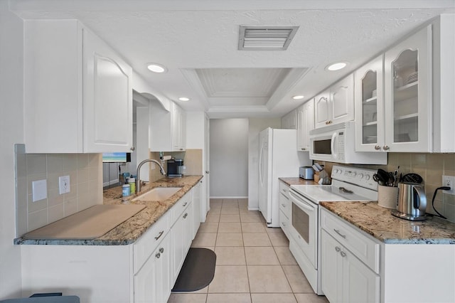 4806 Huntleigh Dr, Sarasota, FL 34233 - kitchen with tasteful backsplash, visible vents, a raised ceiling, a sink, and white appliances