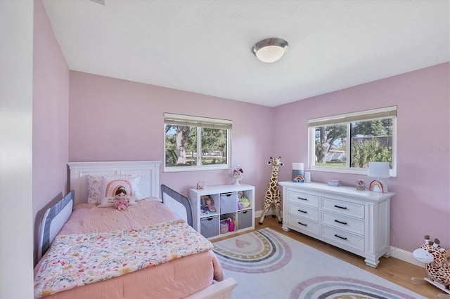 4806 Huntleigh Dr, Sarasota, FL 34233 - bedroom featuring light wood-style floors, multiple windows, and baseboards