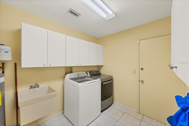 4806 Huntleigh Dr, Sarasota, FL 34233 - laundry room with light tile patterned floors, visible vents, independent washer and dryer, cabinet space, and a sink