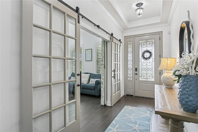13721 Saw Palm Creek Trl, Lakewood Ranch, FL 34211 - foyer featuring french doors, dark wood-style flooring, ornamental molding, a raised ceiling, and a barn door