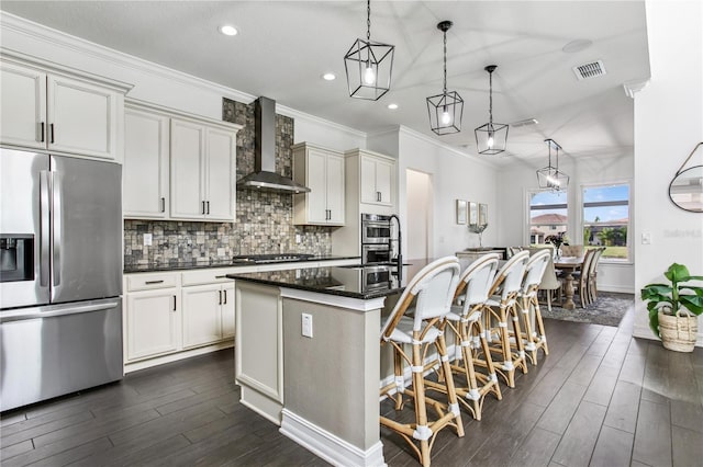 13721 Saw Palm Creek Trl, Lakewood Ranch, FL 34211 - kitchen with wall chimney exhaust hood, a center island with sink, stainless steel appliances, visible vents, and decorative backsplash