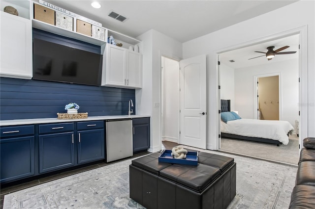 13721 Saw Palm Creek Trl, Lakewood Ranch, FL 34211 - kitchen with white cabinets, visible vents, light countertops, refrigerator, and blue cabinetry