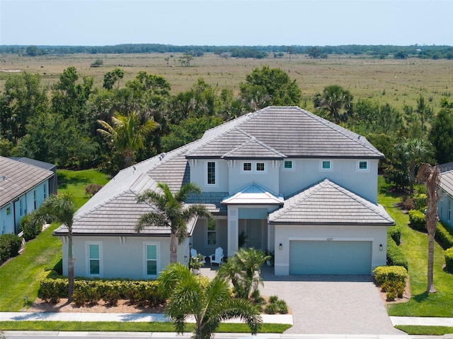 traditional-style home featuring stucco siding, a tiled roof, and an attached garage