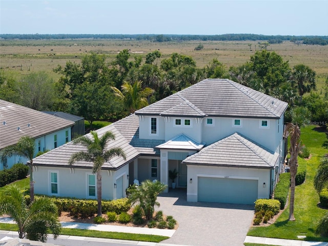 view of front of house featuring stucco siding, a tiled roof, and an attached garage