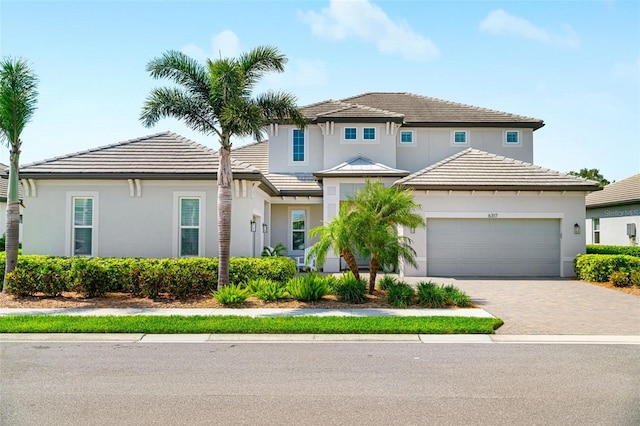 traditional-style home with stucco siding, driveway, and an attached garage