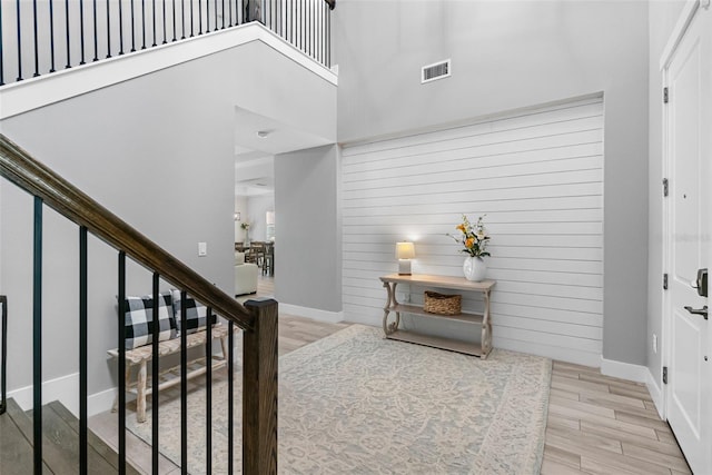 entryway featuring wood finished floors, visible vents, stairs, and baseboards