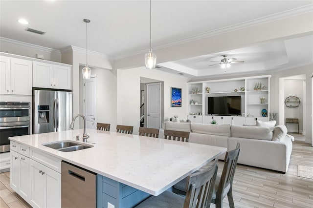 kitchen featuring white cabinetry, a sink, visible vents, stainless steel appliances, and an island with sink