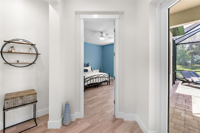 hall featuring light wood-type flooring and baseboards
