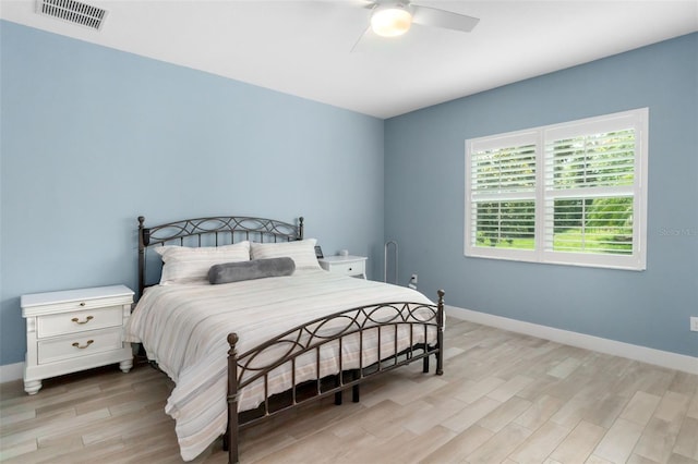 bedroom featuring visible vents, ceiling fan, light wood-style flooring, and baseboards