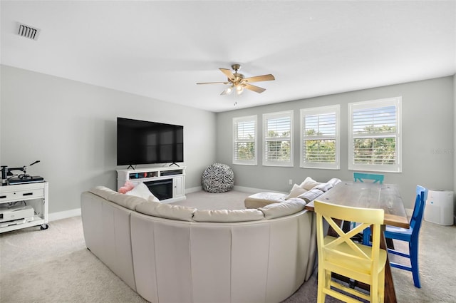 living area featuring visible vents, a ceiling fan, carpet flooring, and baseboards