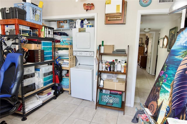 storage area with stacked washer / drying machine and visible vents