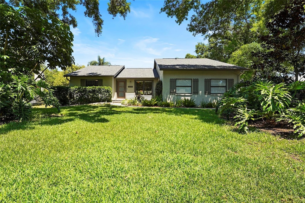 view of front of property with stucco siding and a front lawn