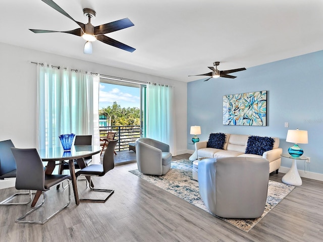 living room featuring baseboards, a ceiling fan, and wood finished floors