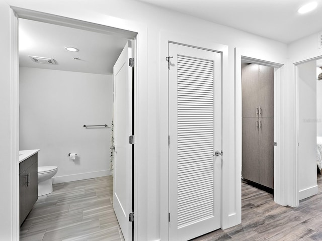 bathroom with toilet, vanity, visible vents, recessed lighting, and baseboards