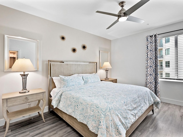 bedroom with baseboards, ceiling fan, and wood finished floors