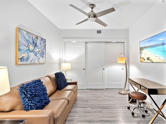 living area with light wood finished floors, visible vents, and a ceiling fan