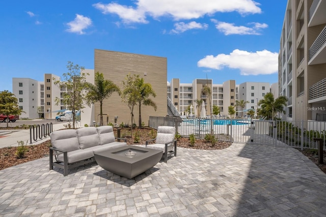 view of patio featuring an outdoor living space with a fire pit and a community pool